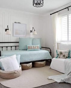 a bedroom with white walls and blue bedding in the corner, along with baskets on the floor