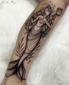 a woman's leg with a mermaid tattoo on it