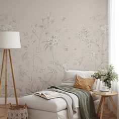 a white couch sitting next to a lamp on top of a hard wood floor under a window