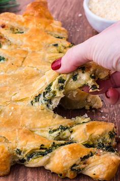 someone is taking a bite out of spinach and cheese casserole on a cutting board