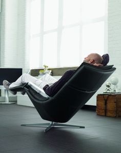 a man reclining in a black leather chair