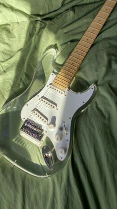 an electric guitar is laying on a green sheet