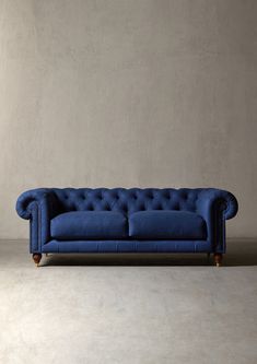 a blue couch sitting on top of a cement floor