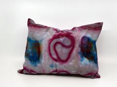 a pillow that has been dyed with pink, blue and purple dyes on it