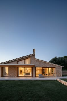 the house is made out of stone and has an open floor plan that matches with the grass