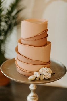 there is a cake that has been stacked on top of each other with flowers in front of it