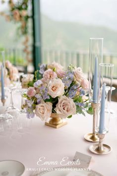 the table is set with flowers and candles