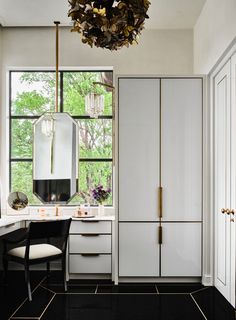 a white and black bathroom with a large mirror, sink, vanity and closet doors