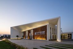 the entrance to city edge entertainment center at dusk, with lights on and grass in front