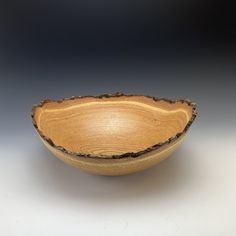 a wooden bowl sitting on top of a white table