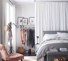 a bedroom with a bed, chair and clothes rack