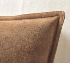 a close up of a brown pillow on a bed