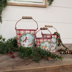 two christmas baskets sitting on top of a wooden table