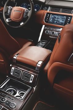 the interior of a car with brown leather seats and steering wheel, center console and dashboard controls