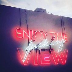 a neon sign that says enjoy the wedding view