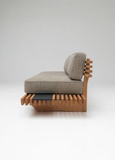 a chaise lounge chair made out of wood and upholstered with grey fabric