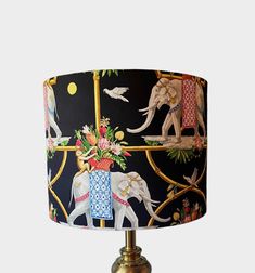 an elephant lampshade is decorated with colorful flowers and elephants on black fabric shade