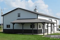 a large white barn with a black roof