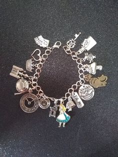 "Silver tone plated metal bracelet with lobster clasp ** 8\" length ** Links are 8×7mm and can easily be adjusted with beading pliers. 17 total charms are lead and nickel free. Zinc alloy metal Charm vary in size:  Alice for example is 33×18mm and the rabbit is 20×15mm Alice charm is gold plated with enamel coloring and the Heart charm is rose gold in color. Cat is antiqued bronze Weighs 1.15oz Great gift for any Alice in wonderland enthusiast. Super cute and full of magic No returns or exchange Metal Charm Bracelet, Alice In Wonderland Merch, Charm Bracelet Aesthetic, Alice In Wonderland Bracelet, Beads Business, James Avery Charm Bracelet, Random Jewelry, Custom Gold Jewelry, Alice In Wonderland Gifts