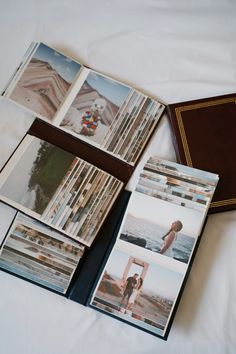 an open book sitting on top of a bed next to pictures