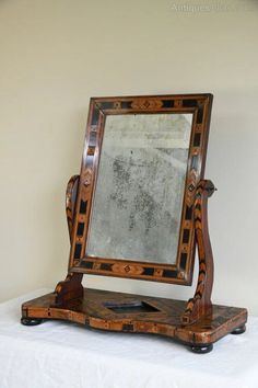 an antique wooden mirror sitting on top of a table