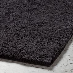 a dark gray rug is laying on the floor