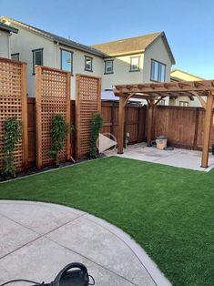 a backyard with artificial grass and wooden fence