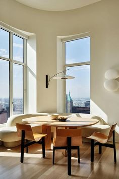 a table and chairs in front of large windows