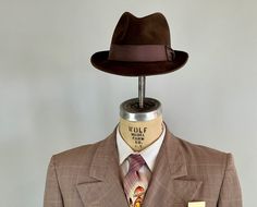 "You'll need this snazzy 1950's fedora to complete your look and turn your suit into an outfit! This fur felt fedora is chocolate brown with a cedar brown grosgrain ribbon band. It has a leather hat band and is fully lined. Made by \"Biltmore\" and sold by \"The Hat Guys\" in Oakland California. This hat is in great vintage condition with no holes, stains, or odors to note. Marked Size: 7 Inner circumference: 22\" Length (at longest point): 11.5\" Width (at widest point): 10.5\" Crown Height: 4\ Vintage Fedora For Kentucky Derby With Flat Bill, Vintage Brown Fedora For Formal Occasions, Formal Fitted Brown Fedora, Retro Fitted Fedora With Curved Brim, Retro Fedora With Curved Brim, Fitted Retro Fedora With Curved Brim, Retro Fedora With Short Brim For Formal Events, Retro Fedora With Short Brim For Formal Occasions, Retro Short Brim Fedora For Formal Events