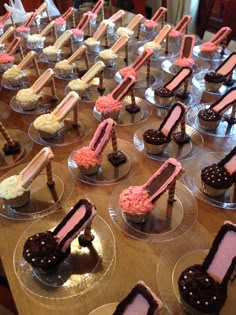 cupcakes with chocolate frosting and pink icing are arranged on clear plates