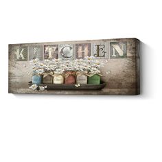 a wooden sign that says kitchen with flowers in the center and letters above it on a shelf