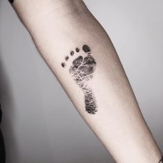 a person's arm with an inked foot print on the inside of it