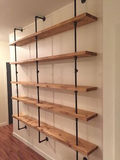 the shelves are made out of wood and have metal pipe brackets on each shelf,