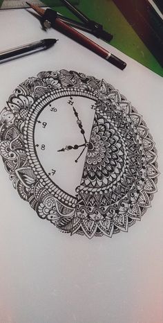 a drawing of a clock on top of a white paper with markers and pencils next to it