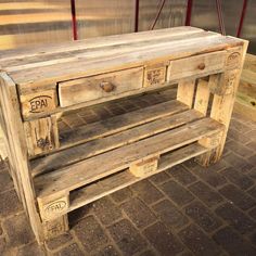 an old wooden table with two drawers on one side and some writing on the other