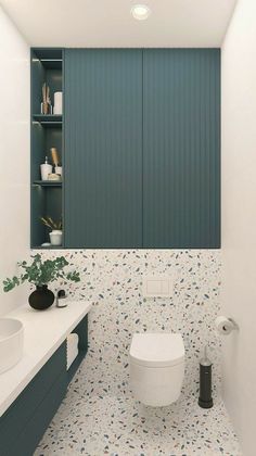 a white toilet sitting under a bathroom mirror next to a sink and cabinets in a room