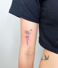 a woman with a tattoo on her arm has a flower and a bird in it