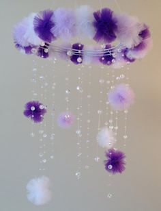 a purple and white mobile hanging from the ceiling with bubbles on it's sides