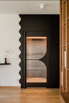 an open door in a room with wooden flooring and white walls on the side