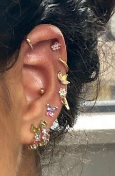 a close up of a person's ear with different colored piercings on it