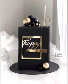 a black and gold birthday cake with candles