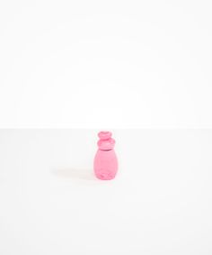 a pink vase sitting on top of a white table