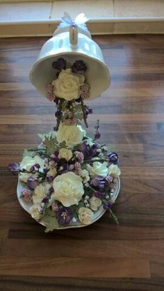 a white hat with flowers on it sitting on top of a wooden floor next to a window