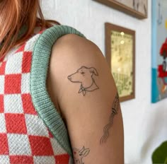 a woman's arm with a dog tattoo on the left side of her arm