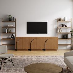 a living room with a large flat screen tv mounted on the wall above a wooden entertainment center