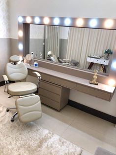 a white chair sitting in front of a large mirror with lights on it's sides