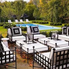 a group of black and white chairs sitting in the middle of a yard next to a pool