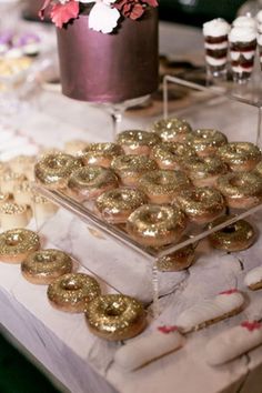 a table topped with lots of donuts and cupcakes