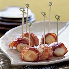 bacon wrapped scallops with toothpicks on a plate