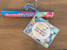 a candy bar and some candies are sitting on a wooden table next to each other